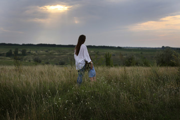 horizontal photo of mother with daughter on a field with wildflowers against a dramatic sky