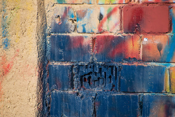 Old damaged graffity wall from bricks and mostly blue color