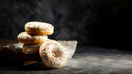 Fresh sweet donuts on dark background and copy space for your decoration 