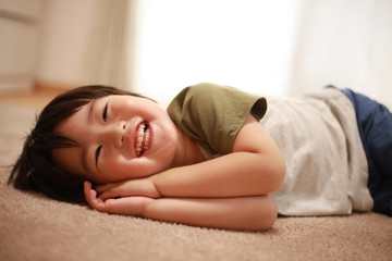 寝転がりながらテレビを観る男の子
