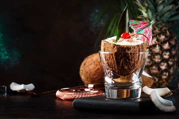 Pina Colada Cocktail in chopped coconut with tropical fruits and bar tools, summer relax concept,...