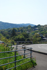 A sidewalk taken at the junction, "Yokoyama Observatory Deck Ent.", in Mie prefecture. you can see the local houses and mountains in the distance.