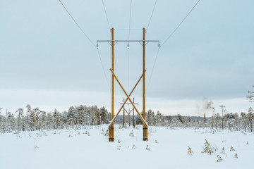 Fototapeta na wymiar Transposition power transmission towers in snowy north forest