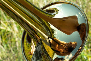 A musical instrument in nature. The golden trumpet reflects the world. Music lesson. Wind...