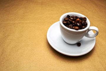 full white cup of coffee beans on a beige background