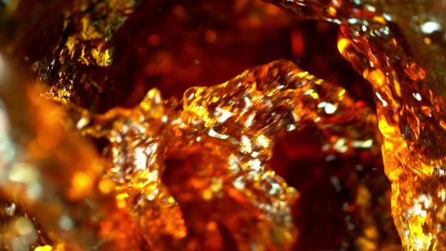 Super slow motion of pouring cola/whiskey or ice tea drink in twister shape. Filmed on high speed cinema camera, 1000 fps.