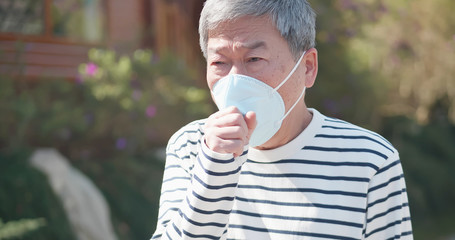 elder coughs and wears mask