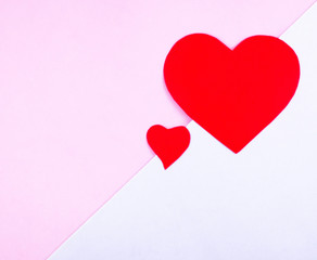 Two red hearts on a pink and blue background with space for text.
