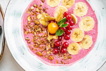 pink porridge with banana and berries on a white background. tasty porridge with fruits. healthy breakfast