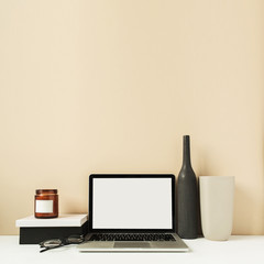 Laptop with mockup blank copy space screen on table. Office desk workspace with decorations. Minimal freelancer co-working concept.