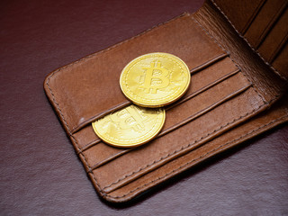 Two bitcoin on wallet. Cryptography e-commerce concept. Stock photo.