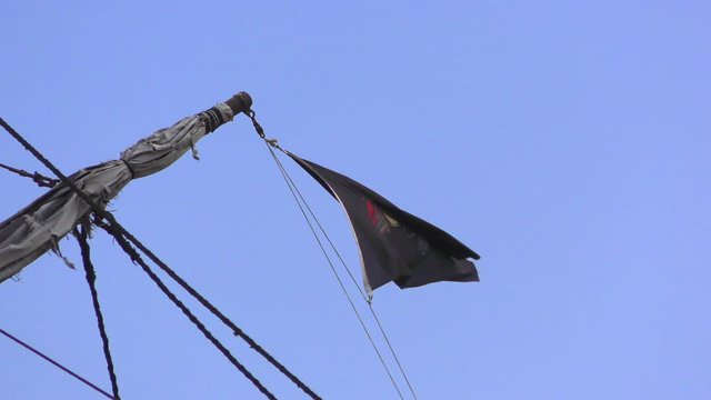 Pirate flag on a pleasure boat evolving against blue sky