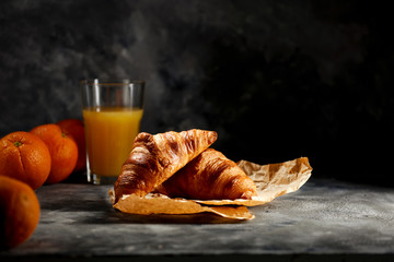 Dark mood background and fresh croissants on board.Free space for your decoration and breakfast time.  - obrazy, fototapety, plakaty