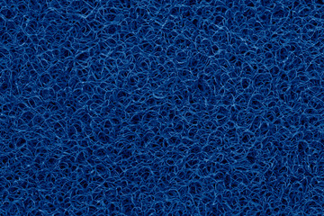 Close-up detail deep classic blue plastic doormat texture. Neutral abstract backdrop surface. Color...