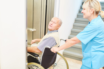 Caregiver pushes senior man in wheelchair