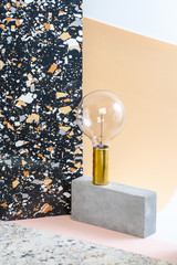 Installation of geometric shapes and lamps on a stylish modern background with a Terrazzo pattern.