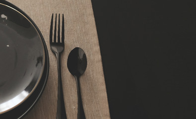 a set of set plates cutlery on black wooden dinner table with with Prop. copy space