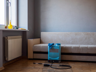 interior of apartment with sofa infected with bed bugs. Poison spray, gloves, poison container