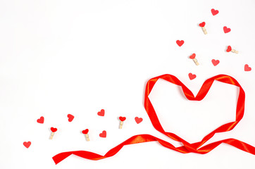 Valentine's day concept. Heart made of bright red ribbon with decorative clothespins with hearts on a white background