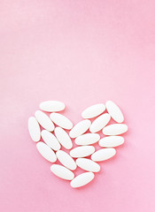 Heart shape made from pills for therapy, concept of treatment and health care on pink