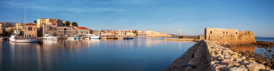 Fototapeta premium Panorama of Old harbor of Chania with the lighthouse and fortification at sunrise, Crete, Greece