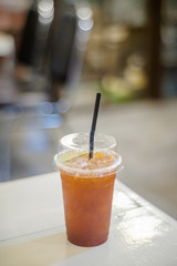 Ice tea with plastic glass on white table