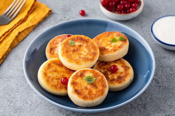 Syrniki or cottage cheese pancakes with fresh red currant. Tasty healthy breakfast.