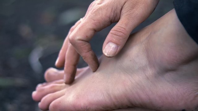 Fingers walk over one foot and caresses back up. Close up slowmotion