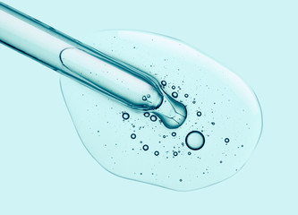 Liquid transparent serum with pipette on a blue screen of microscope
