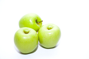 Three green apples on a white background. The concept of a healthy diet and vegetarianism.