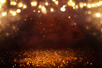 Naklejka premium background of abstract glitter lights. gold and black. de focused