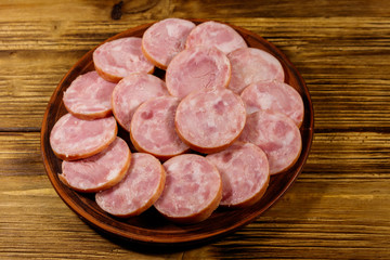 Ham sausage on a plate on wooden table