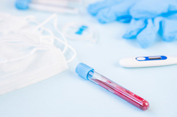 hands of a lab technician with a tube of blood sample / lab assistant holds a blood test tube for...