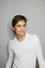 Studio portrait of handsome teenage boy isolated on grey background.