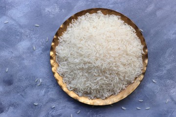 Uncooked Indian Surti Kolam Rice in a copper vessel. with mint leaves, spices like cinnamon and...