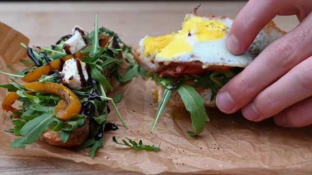 Man eating italian bruschetta with eggs and salad
