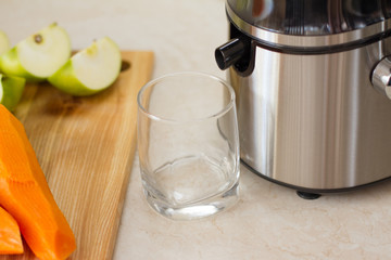 detox. smoothies. the process of making juice in the kitchen. A glass of fresh carrot juice. carrot and Apple on the table. detoxification, vegetarian diet. juicy healthy vitamin drink. juicer.
