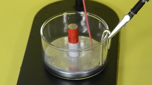 Faraday motor with mercury pool and a conducter that moves in circles around a magnet when a current flows.