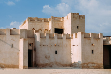 Arabic classic house in a Bedouin village against a blue sky. Arabic architecture made of yellow sand bricks