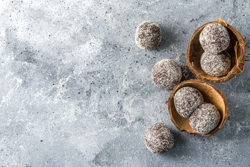 Homemade healthy protein energy balls in a coconut bowl with dried apricots, raisins, walnuts, almonds and coconut. Healthy sweet food.