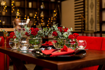 horizontal photo of several glass vases surrounded by candles
