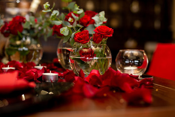 Fototapeta na wymiar horizontal photo of several glass vases surrounded by candles and rose petals