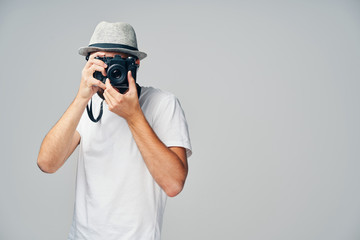 Young man taking picture with analog camera isolated on grey background