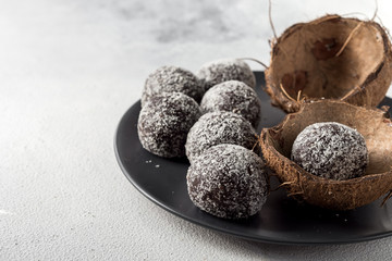 Homemade healthy protein energy balls in a coconut bowl with dried apricots, raisins, walnuts, almonds and coconut. Healthy sweet food.