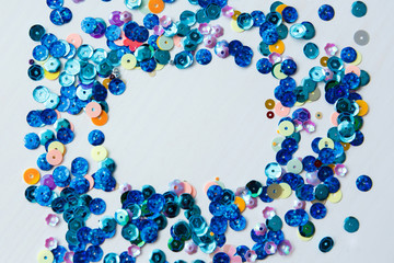Colored and blue sequins on a white background