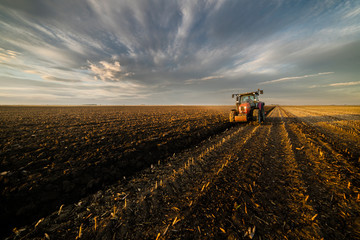 Tractor plowing fields in sunset
