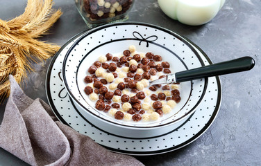 Wholegrain chocolate, milk balls and milk. Healthy cereal breakfast. Baby breakfast. Baby eating. Balanced diet.