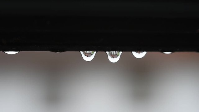 Regentropfen tr&ouml;pfeln langsam von einem Dach. Trauer Hintergrund