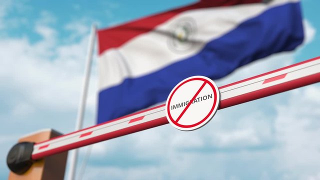 Barrier gate with no immigration sign being closed with flag of Paraguay as a background. Paraguayan Border closure or immigration ban