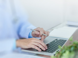 The doctor enters the examination data on a computer.